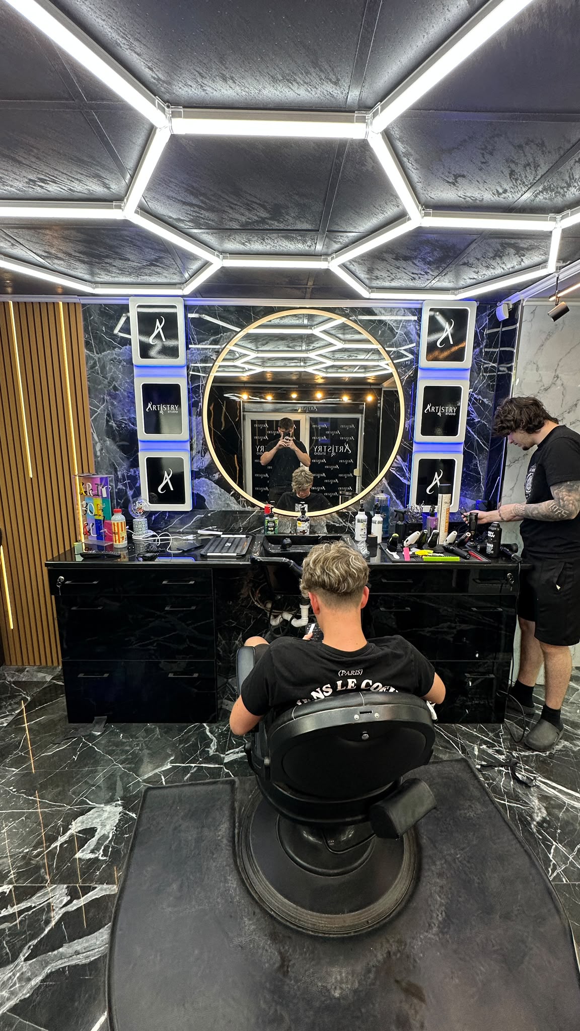 Interiorul Artistry Studio — frizerie în Mediaș, oglindă rotundă și tavan hexagonal